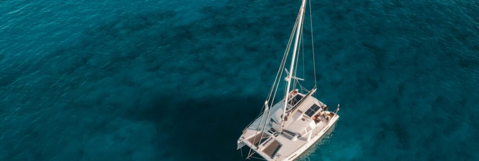 white and blue boat on blue sea